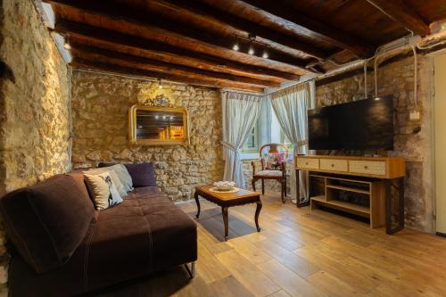 a living room with a couch and a television at Stefanos House in Afitos
