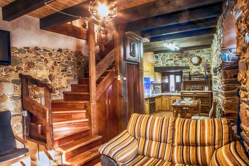 a living room with a couch and a stone wall at La Casina del Pozo in Bembibre