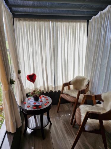 a living room with a table and chairs and a window at Cabana Davos in Timbe do Sul