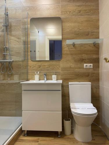 a bathroom with a sink and a toilet and a mirror at Lustforlife in Odesa