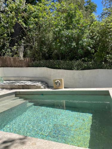 a pool of water next to a wall and trees at Villa la Roma in Aix-en-Provence