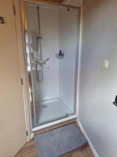a shower with a glass door in a bathroom at Heuvelzicht in Wortegem