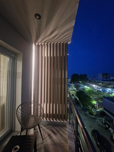 a balcony with a chair and a window at night at 8 Blocks Apartments - Alexandroupoli in Alexandroupoli