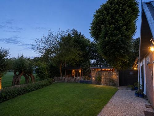a yard with a fence and a house at Holiday Home de Binnengouw incl Hottub in Hoogwoud