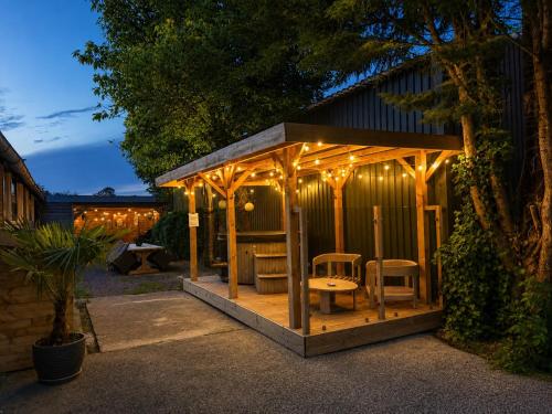 a gazebo with a table and chairs and lights at Holiday Home de Binnengouw incl Hottub in Hoogwoud