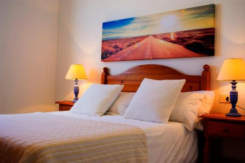 una camera da letto con un letto bianco con due lampade di La Casita Azul a Punta de Mujeres