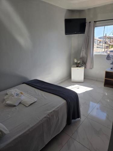 a bedroom with a bed and a window with a television at Hotel Goldem Park in Brasília