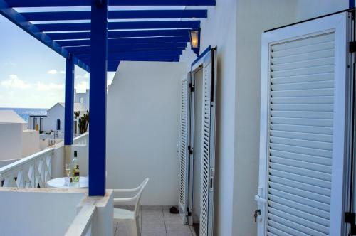 een balkon met blauwe zuilen en een tafel en stoelen bij La Casita Azul in Punta de Mujeres