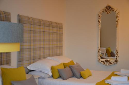a white couch with yellow pillows and a mirror at Edinburgh37 in Edinburgh