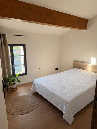 a bedroom with a white bed and a window at Maison S&L in Le Pontet