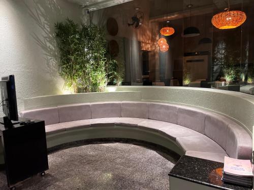 a large couch in a room with plants on the wall at Primum Palace Hotel in Dracena
