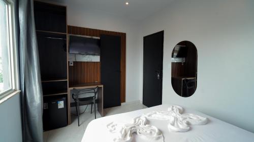 a bedroom with a bed and a desk and a mirror at Barrudada Palace Hotel-Boa Vista in Boa Vista
