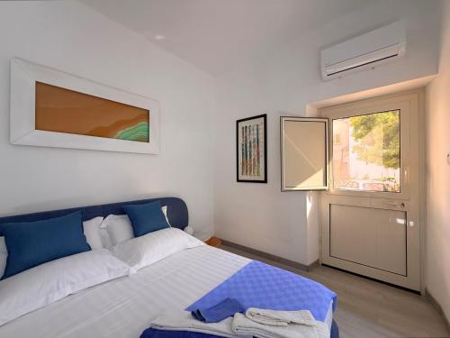 a bedroom with a bed and a window and a door at B&B Edda Maison Centralissimo sul Lungomare con Posto Auto e Giardino Privato in Sperlonga