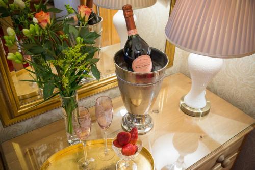 彭里斯的住宿－Brooklands Guest House，一张桌子,上面放着一瓶葡萄酒、眼镜和鲜花