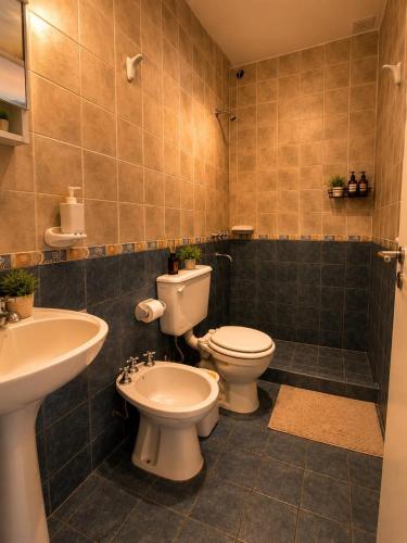 a bathroom with a toilet and a bidet and a sink at Destino Wilde in Resistencia