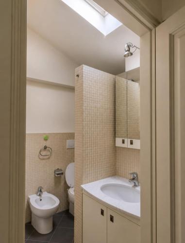 a bathroom with a sink and a toilet and a mirror at Maison Cecilia in Rapallo