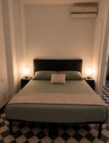 a bedroom with a large bed with two lamps at Maison Cecilia in Rapallo