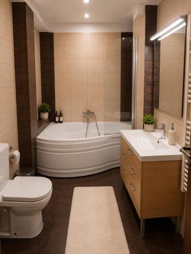 a bathroom with a tub and a toilet and a sink at King Apartment Bucharest in Dudu