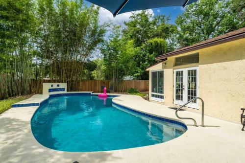 a swimming pool in a backyard with an umbrella at Sherylee's Poolside Retreat - Team Joseph Ellen in Jacksonville
