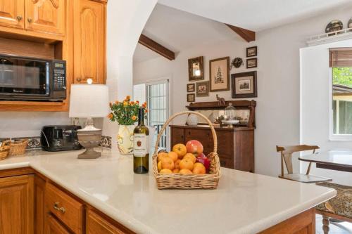 a kitchen with a basket of fruit on a counter at Sherylee's Poolside Retreat - Team Joseph Ellen in Jacksonville
