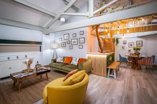 a living room with a yellow couch and a table at Queen's Loft in Windermere