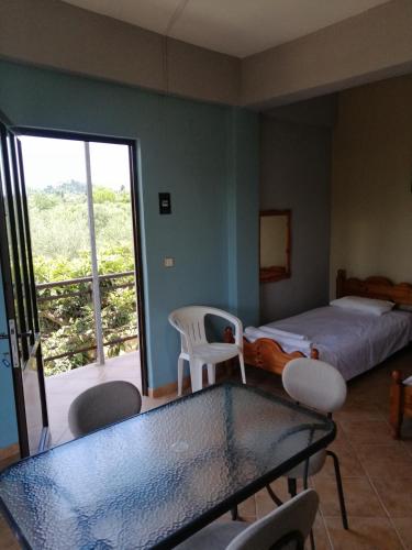 a bedroom with a bed and a table and chairs at Armonia Studios in Agios Georgios