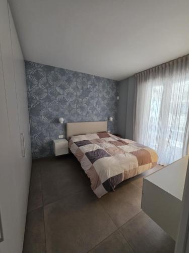 a bedroom with a bed and a blue and white wall at Casa Alma in Lido di Fermo