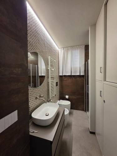 a bathroom with a sink and a toilet and a mirror at Casa Alma in Lido di Fermo
