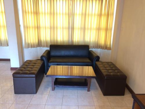 a living room with a couch and a coffee table at Kraisaeng Place in Phitsanulok