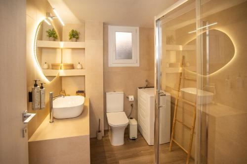 a bathroom with a toilet and a sink and a shower at Cerro Fine Living in Ermoupoli