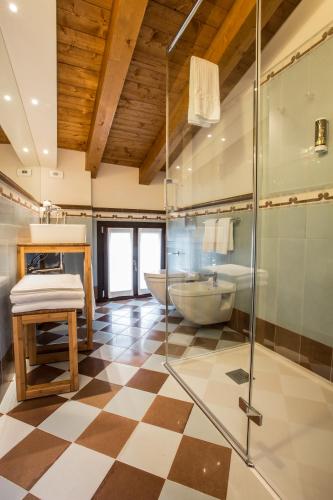 a bathroom with a glass shower and a tub at Casa Delneri Boutique Hotel Adults Only in Aquiléia