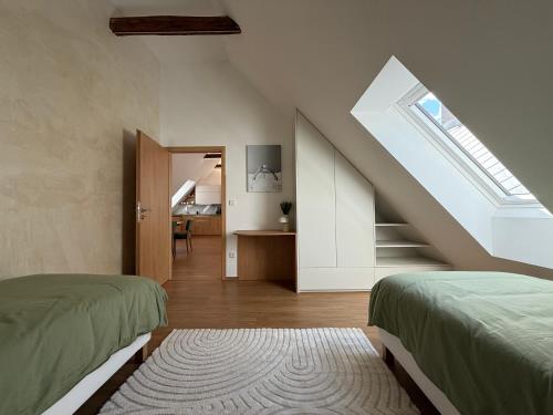 a attic bedroom with two beds and a staircase at Apartmány u čalouníků in Litomyšl