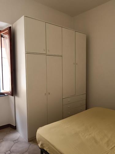 a bedroom with white cabinets and a bed at Casa Cavour 15 in Porto Santo Stefano