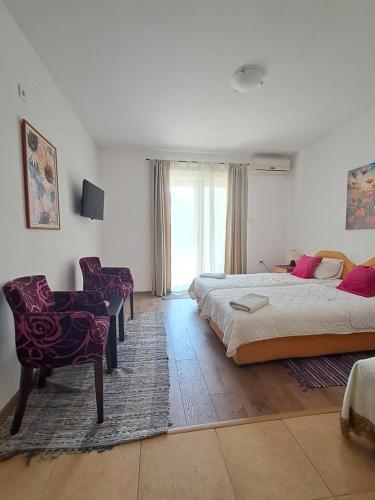 a bedroom with a bed and a desk and a chair at Resort "Maslinjak" in Budva