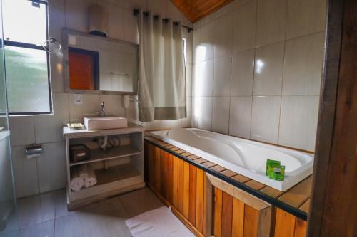 a bathroom with a bath tub and a sink at Café e Cabanas Lenha no Fogo in Urubici