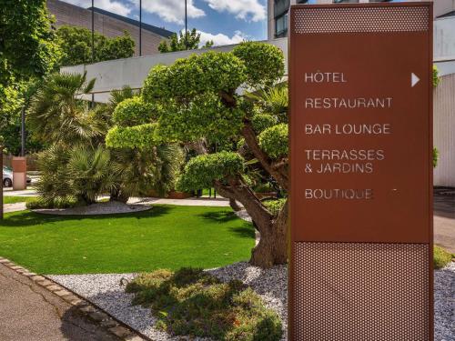 a sign in front of a building with a park at Mercure Dijon Centre Clemenceau in Dijon