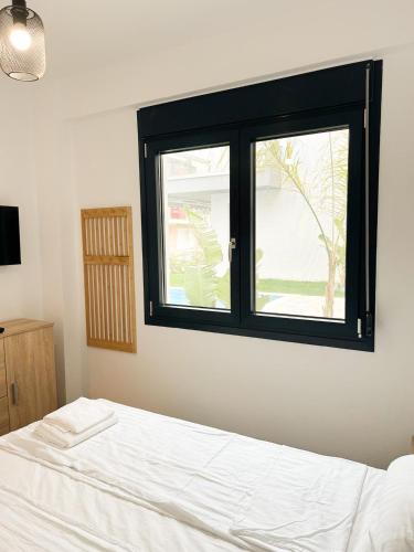 a bedroom with a bed and a window at Sea Shell Apartment - Paralia Ofriniou, Swimming pool, Starlink WIFI in Orfánion
