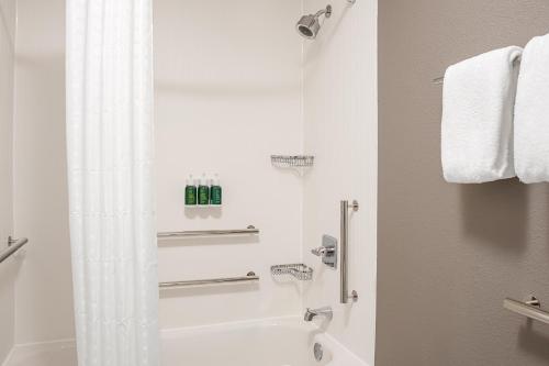 a white bathroom with a shower and a tub at Courtyard Paducah West in Paducah