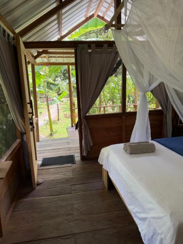 a bedroom with a bed with a canopy and a window at Pal Mar in Nuquí