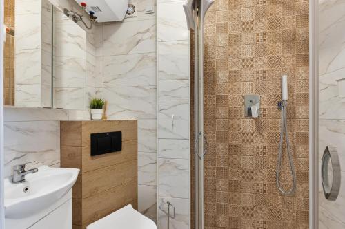 a bathroom with a shower with a toilet and a sink at Lublin Old Town Studio by BookingHost in Lublin