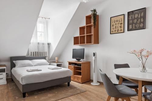 a bedroom with a bed and a table and chairs at Lublin Old Town Studio by BookingHost in Lublin