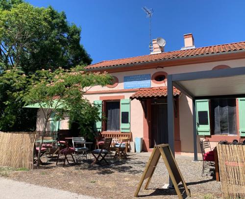 a house with a table and chairs in front of it at La Maison d'Ecluse No17 - Chambres d'hôtes in Castelsarrasin