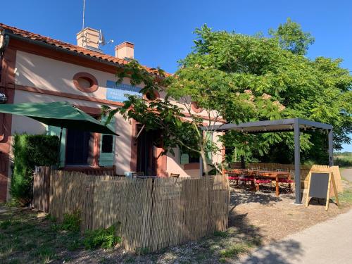 a house with a wooden fence in front of it at La Maison d'Ecluse No17 - Chambres d'hôtes in Castelsarrasin
