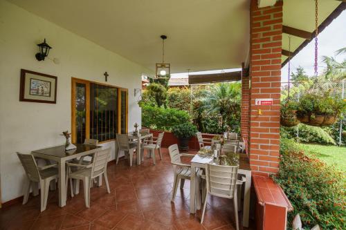a patio with tables and chairs and a brick wall at Finca Hotel 12 Palmas- Aeropuerto JMC in Rionegro