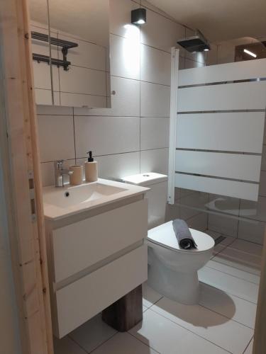 a white bathroom with a toilet and a sink at Leni in Ierissos