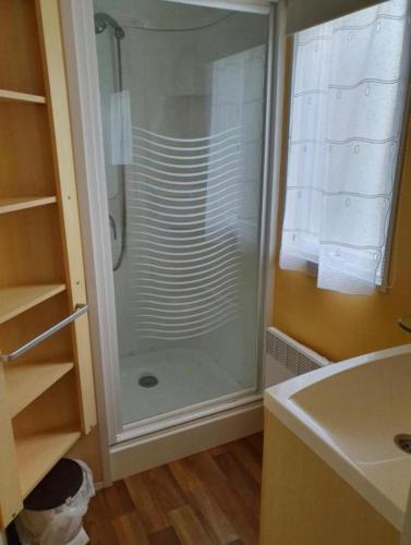 a glass shower in a bathroom with a sink at Puy Rond Camping in Bressuire