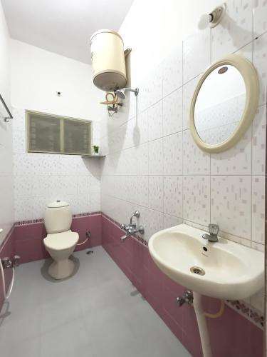 a bathroom with a sink and a mirror and a toilet at Flickstays Hazel in Bangalore