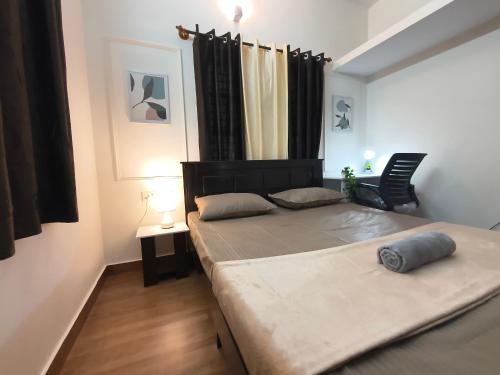 a bedroom with a bed and a chair in it at Flickstays Hazel in Bangalore