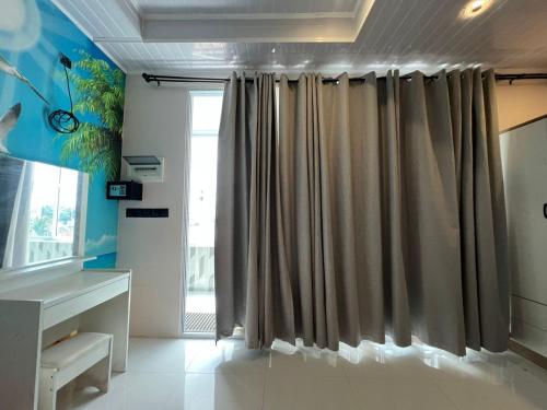 a bathroom with a shower curtain and a desk at Ege Inn in Guraidhoo