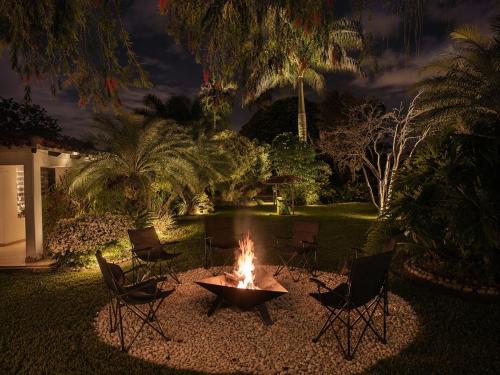 a fire pit in the middle of a yard at night at Villa de lujo a 20 mins Buga con Piscina privada, Jacuzzi y BBQ in Guacarí